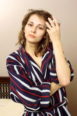 woman in a bathrobe suffering from a headache