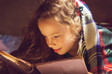 Vintage portrait of cute girl reading a book in cold day