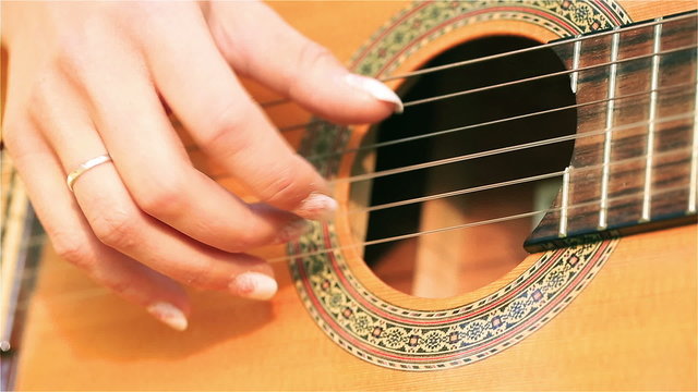 Woman hands touching guitar chords, steadycam shot