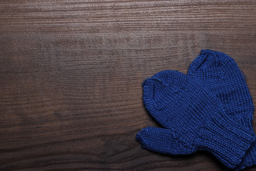 blue mittens on brown wooden background