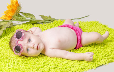 Beautiful little girl on green carpet