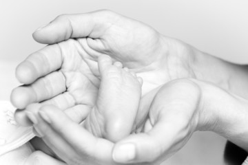 Closeup of tiny foot in mother's hands