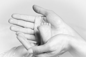 Closeup of tiny foot in mother's hands