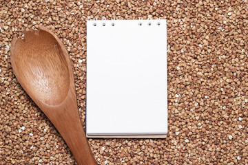 buckwheat with brown wooden spoon and notepad