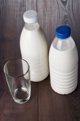 empty glass and two bottles of milk
