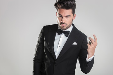 handsome young man in tuxedo snapping his finger