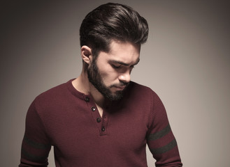 man wearing a burgundy sweater, looking down