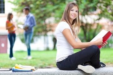 Smiling student sitting out of her school