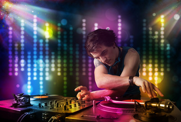 Obraz na płótnie Canvas Dj playing songs in a disco with light show