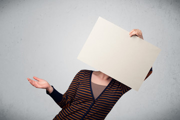 Woman holding in front of her head a paper with copy space