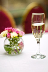 Bouquet of roses and glass of champagne