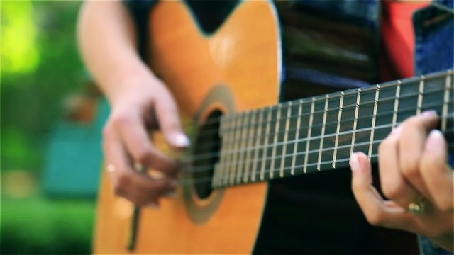 Woman playing on the guitar, steadycam shot