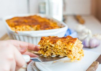 fed meat lasagna on a white plate, hand