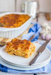 piece of meat lasagna with mushrooms on a white plate