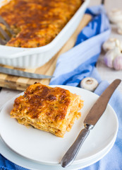 piece of meat lasagna with mushrooms on a white plate