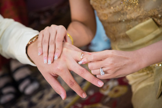 The bride wearing a wedding ring for her groom