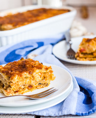 eating a piece of meat lasagna with mushrooms, blue towel