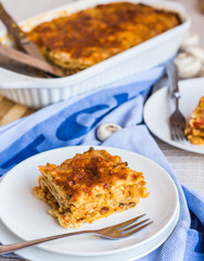 piece of meat lasagna with mushrooms, cutlery, .Italian food