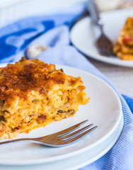 piece of meat lasagna with mushrooms, cutlery, .Italian food