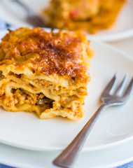 piece of meat lasagna with mushrooms, cutlery, .Italian food