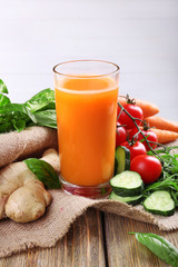 Glass of fresh carrot juice and vegetables