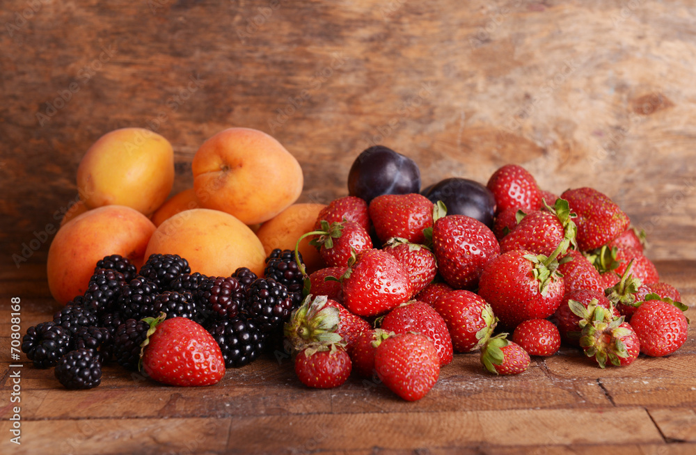 Poster ripe fruits and berries on wooden background