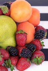 Naklejka na ściany i meble Ripe fruits and berries on striped background