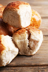 Tasty buns with sesame on color wooden background