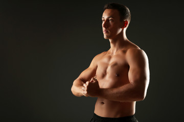 Fototapeta premium Handsome muscle young man on dark background