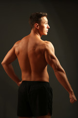 Fototapeta premium Handsome muscle young man on dark background