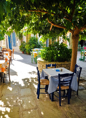 Under tree cafe tables on the village square, Vourliotes, Samos, - obrazy, fototapety, plakaty