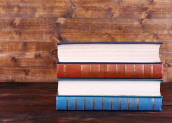 Books on wooden table on wooden wall background