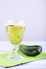 Cucumber cocktail on napkin on wooden table on light background