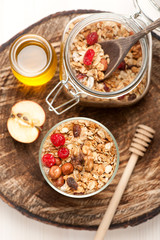 Granola with nuts, dried fruit and honey on wooden background