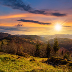 fence on hillside meadow in mountain at sunset