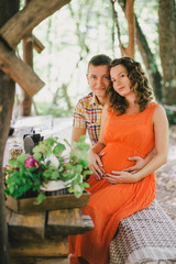 Pregnant woman having lunch with her husband in a forest