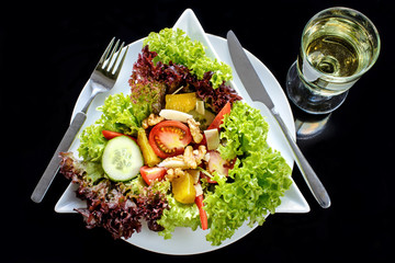 gemischter Salat mit Weißwein auf schwarz