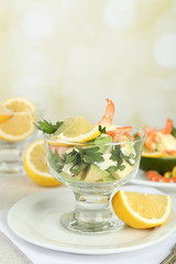Tasty salads with shrimps and avocado in glass bowl and