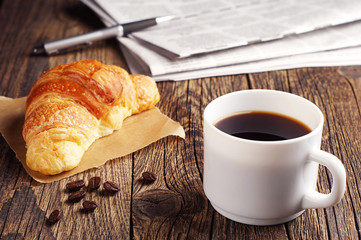 Coffee, croissant and newspaper