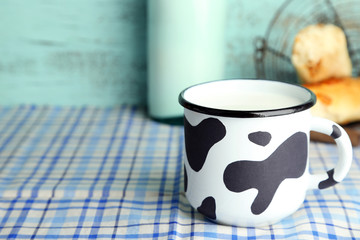Retro mug and bottle of tasty milk, on table
