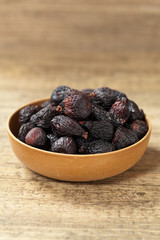 Black dried figs on a wooden surface