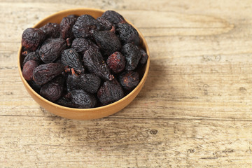 Black dried figs on a wooden surface
