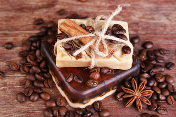 Organic soap with coffee beans and spices on wooden background