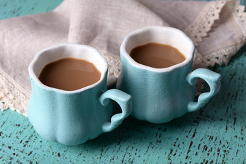 Cups of coffee with napkin on wooden table