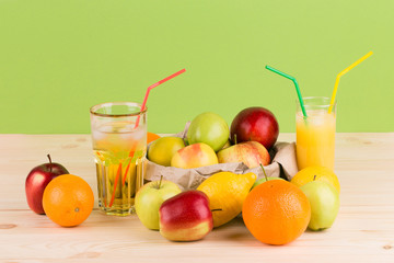 Orange and apple juices on wooden table.