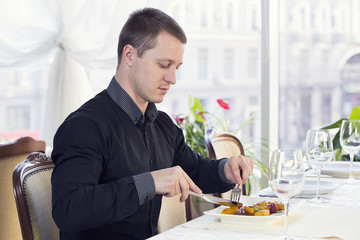 young man having dinner in a restaurant