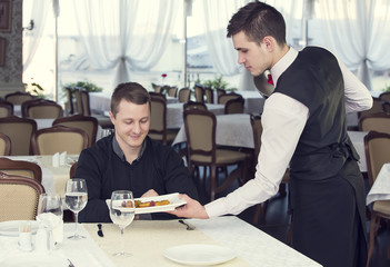 young man having dinner in a restaurant