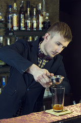 young man working as a bartender in a nightclub bar