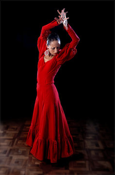 young Spanish woman dancing flamenco in traditional red dress