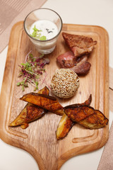 Meat and grilled eggplant on wooden plank